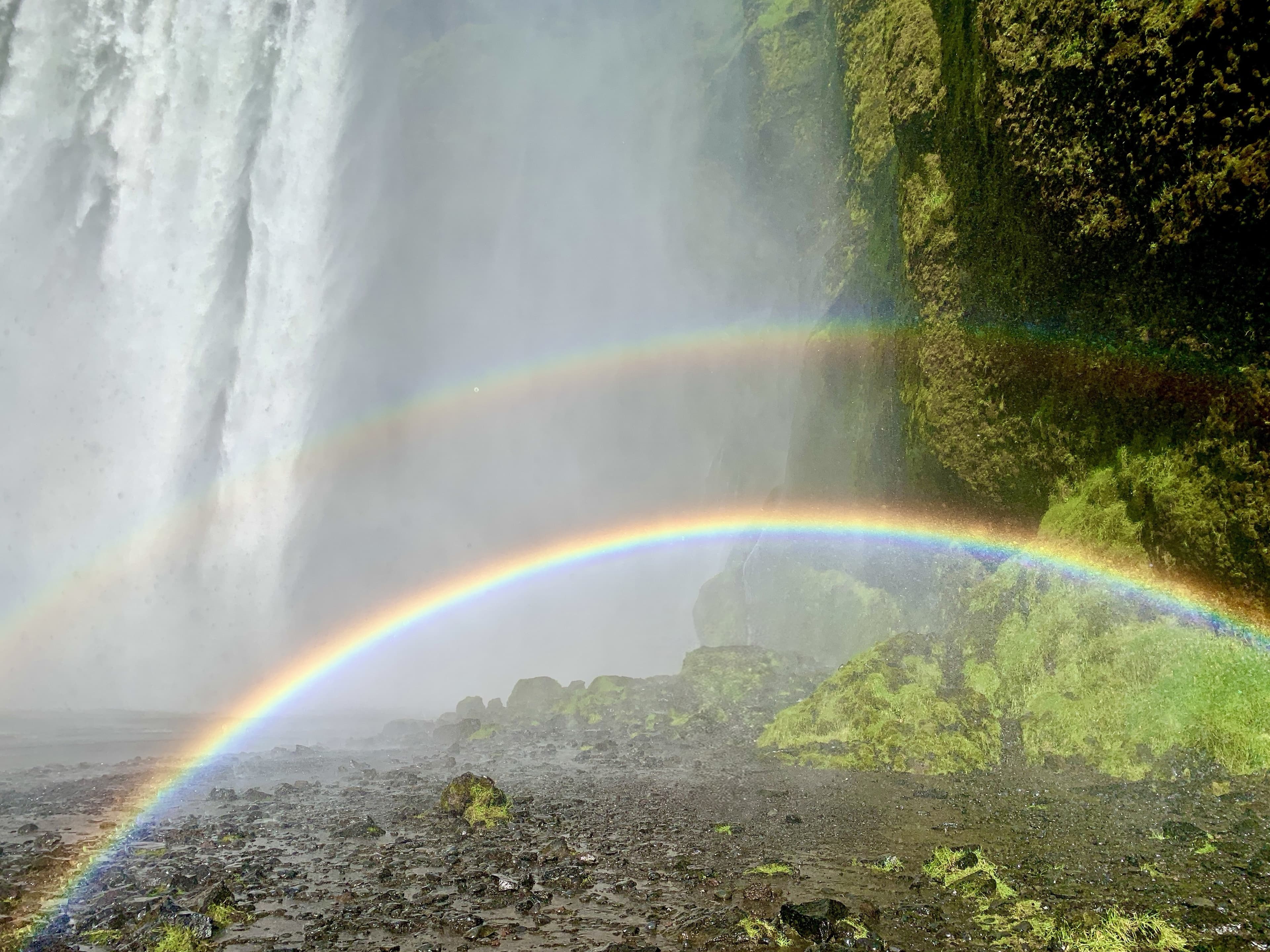 A double rainbow arcing over an Icelandic waterfall