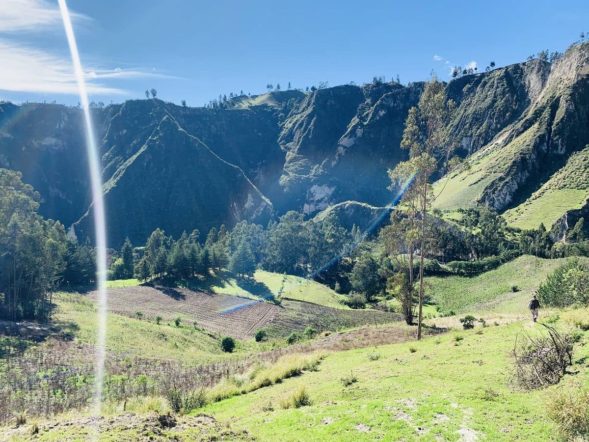Sunlit Andean valley with a distant hiker